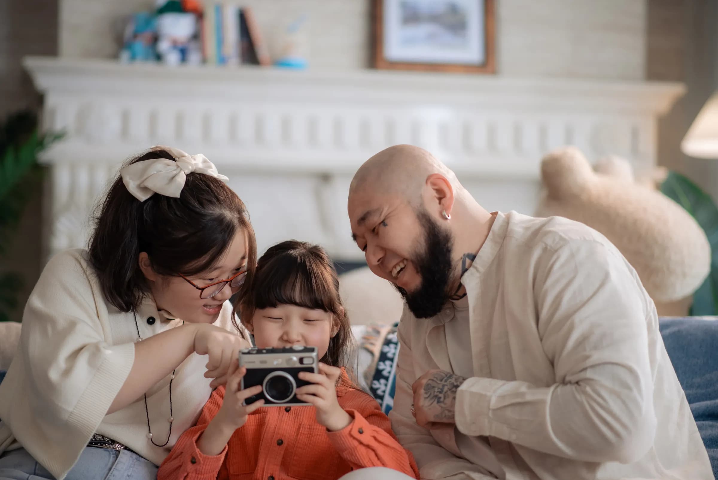 Close family portrait — mother, daughter, and father gathered around a camera